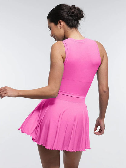 Falda acampanada con cintura media, corte A, bajo con volantes, pantalones cortos y bolsillos incorporados.