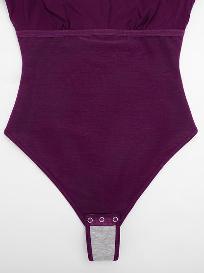 Body moldeador todo en uno con cuello drapeado brillante, sujetador incorporado y tanga con cierre a presión en la entrepierna.